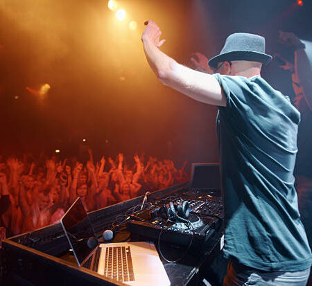 Shot of a young deejay entertaining the crowd at a concert. This concert was created for the sole purpose of this photo shoot, featuring 300 models and 3 live bands. All people in this shoot are model released.