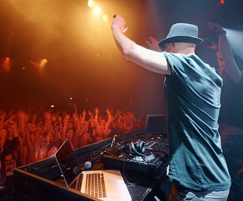 Shot of a young deejay entertaining the crowd at a concert. This concert was created for the sole purpose of this photo shoot, featuring 300 models and 3 live bands. All people in this shoot are model released.